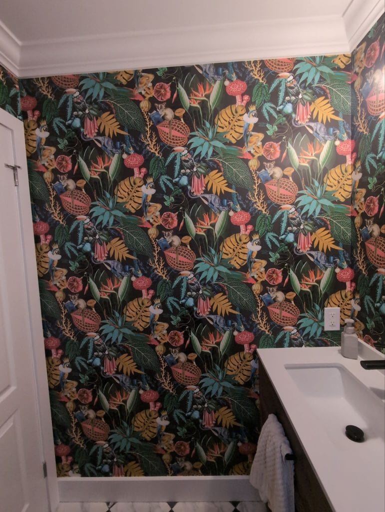 Bold tropical wallpaper installation in a Burlington powder room featuring colourful botanical patterns, exotic birds, and dark dramatic tones. Professional wallpaper installation by DW Painting & Wallpapering.