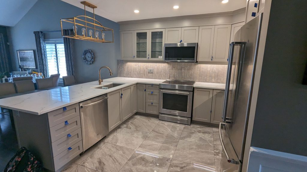 Professionally refinished kitchen cabinets in a Hamilton home featuring a durable painted finish and updated colour scheme.