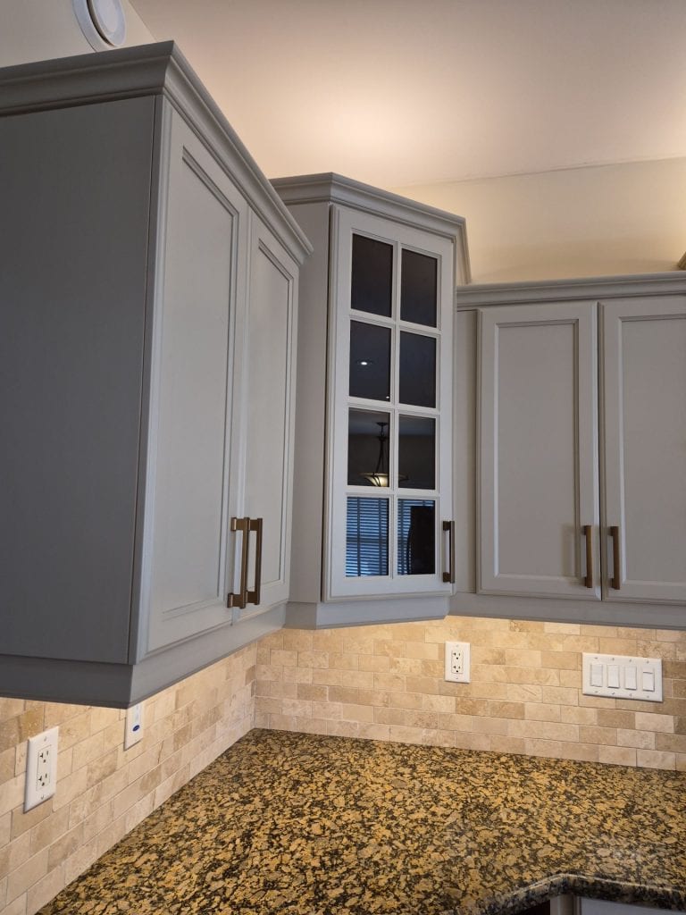 Close-up of professionally refinished kitchen cabinets showing smooth factory-like finish and detailed craftsmanship.